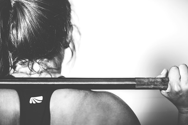 Une femme lors d'une séance de crossfit à la barre.
