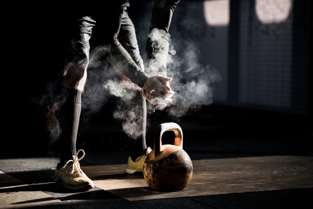 Un homme s'entraine avec un kettle bell