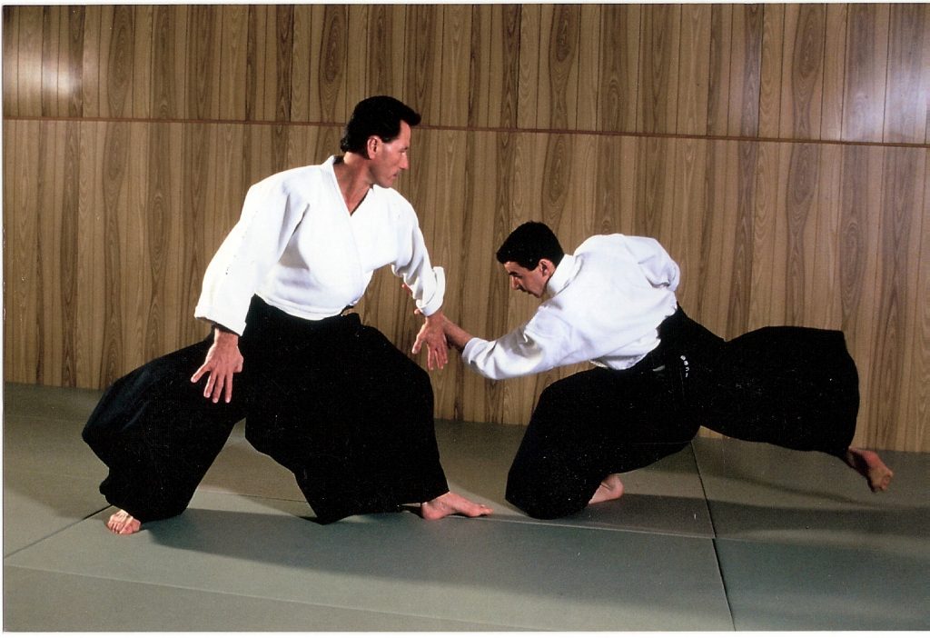 Un homme fait une prise d'aikido sur un autre