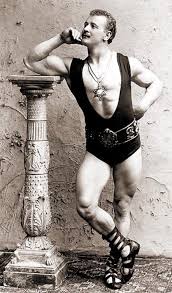 Référence aux origines de la musculation, Sandow pose avec une colonne de style grec.