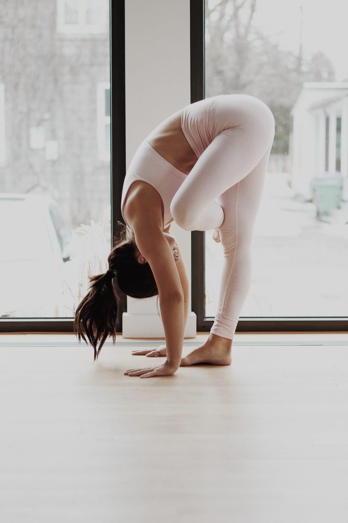une femme réalisant un exercice de yoga dans un studio