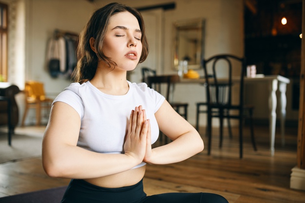 Une femme réalise un exercice de méditation pour améliorer sa proprioception.