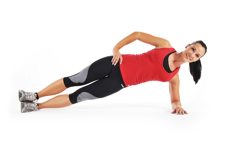 Une femme réalise un gainage latéral