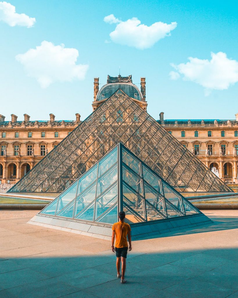 Un sportif face à la pyramide du Louvre.