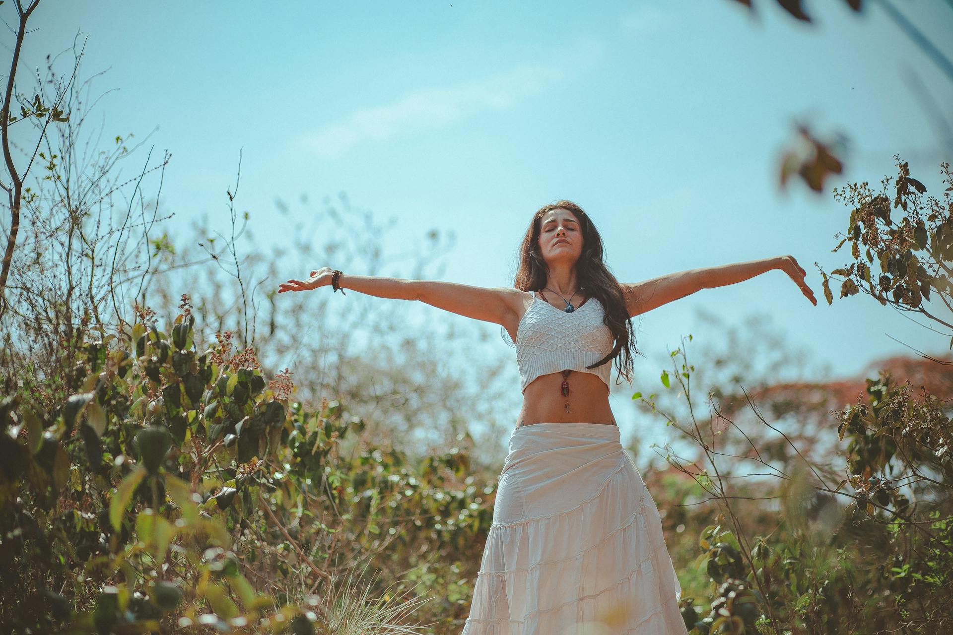 Une femme réalise des postures de yoga en plein air et se détend.