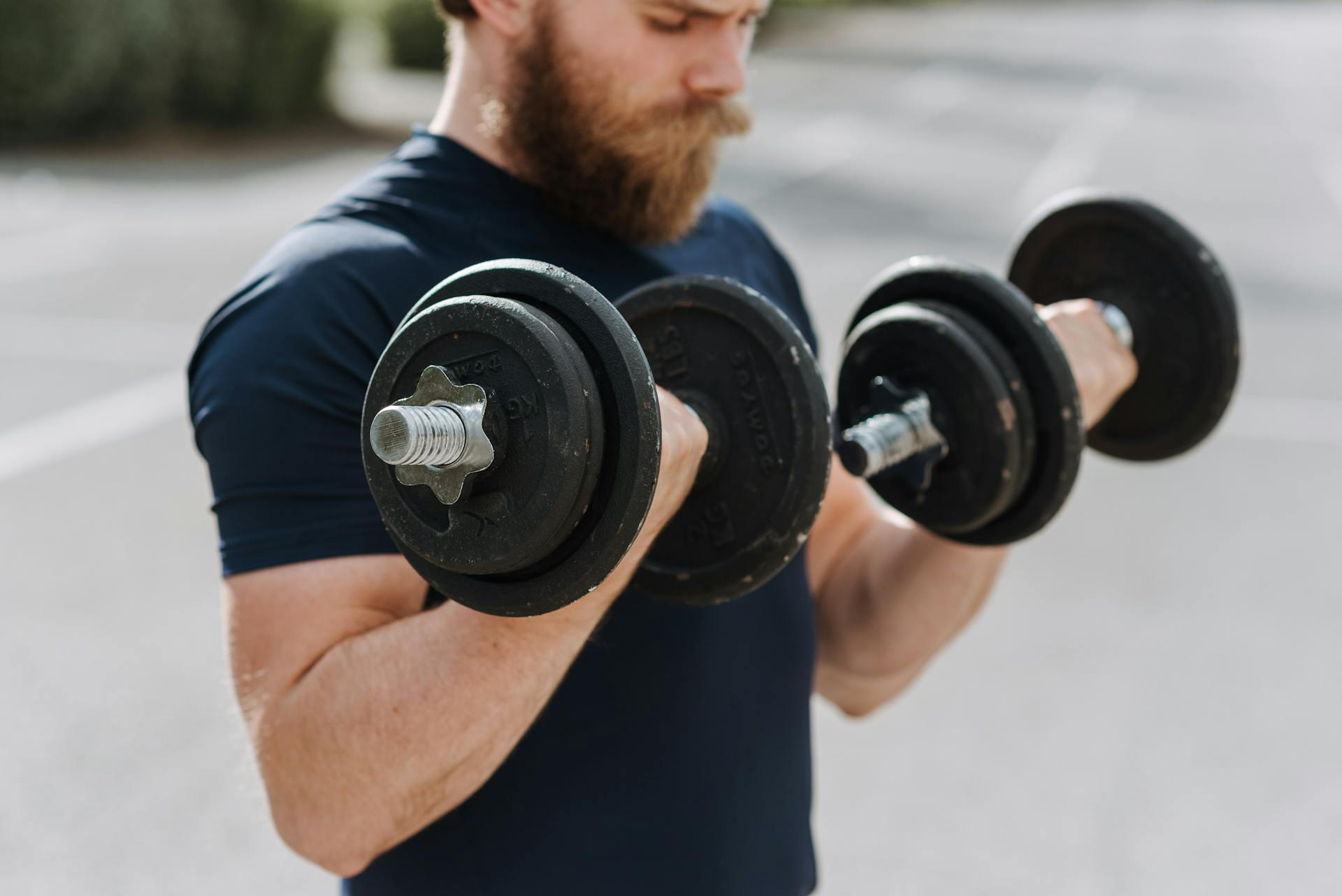 Un homme se muscle avec des haltères lestées.
