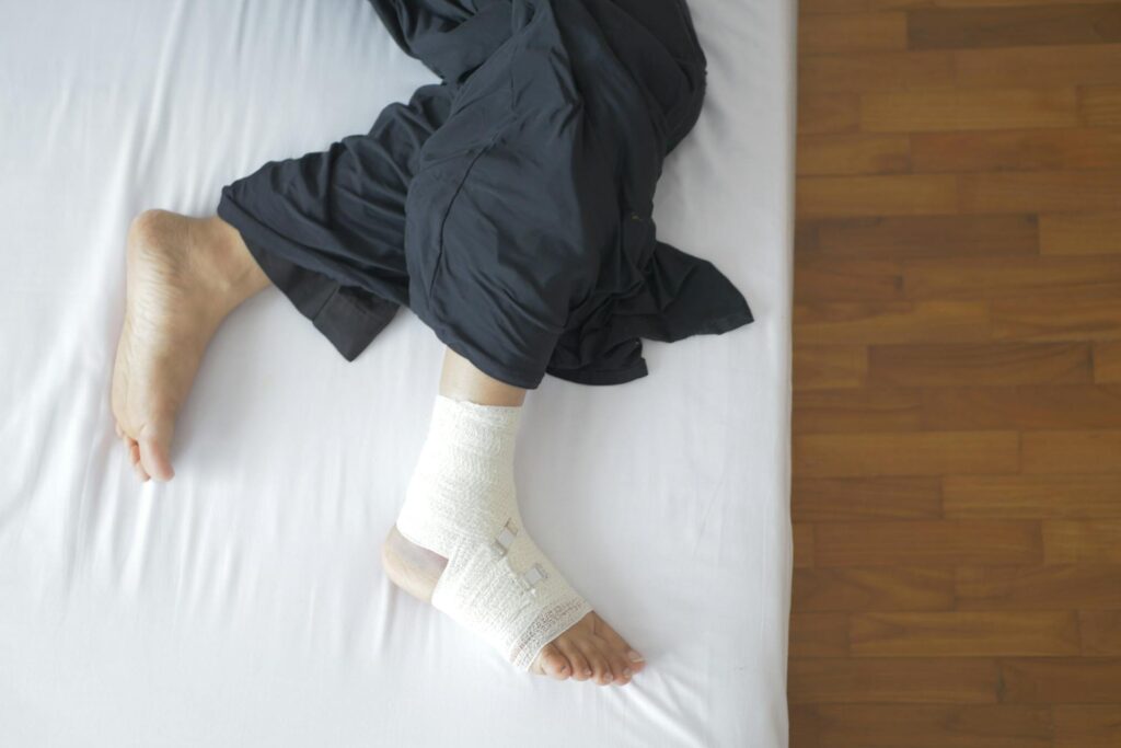 Une personne allongée porte des bandes de compression à la cheville.