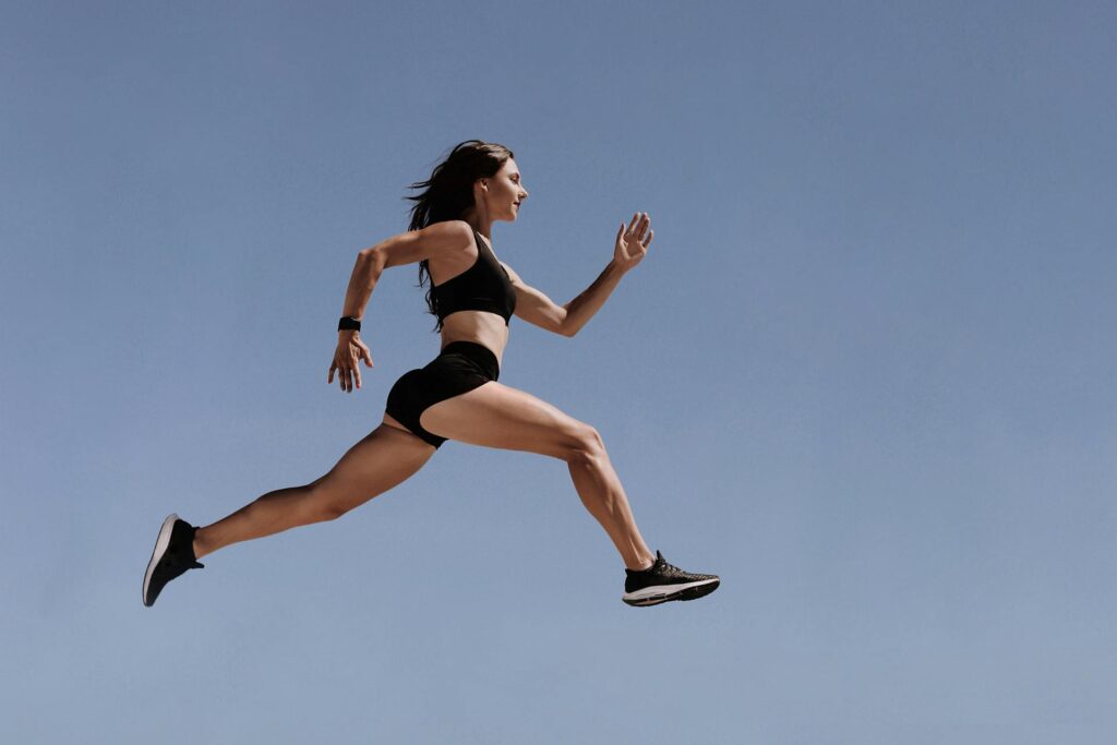 Une femme dans les airs en pleine foulée bondissante.
