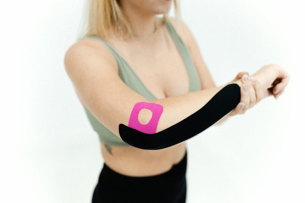 Une femme en tenue de sport a fait du strapping sur son coude suite à une tendinite.