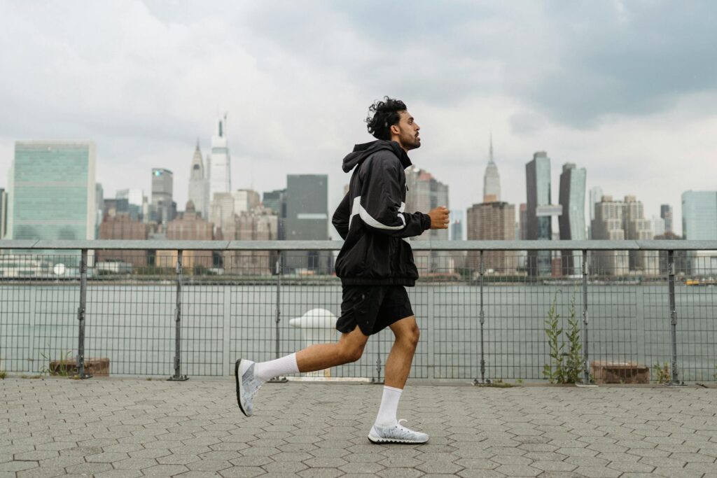 Un homme court en tenue de sport face à des immeubles.