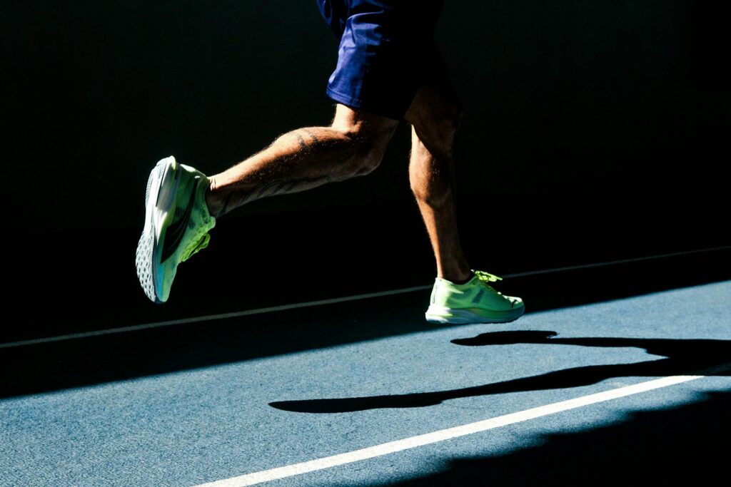 Un homme qui court sur route en baskets et short de sport.