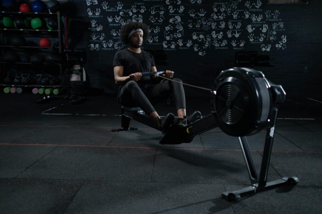 Un sportif sur un rameur s'entraîne.